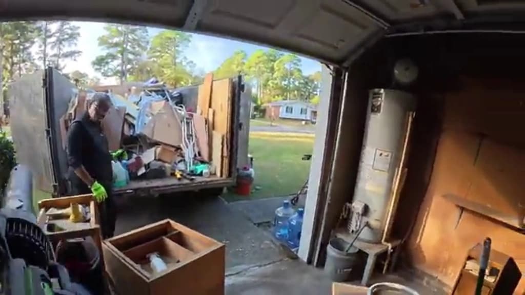 Junk removal truck loaded outside a garage part way through a cleanout
