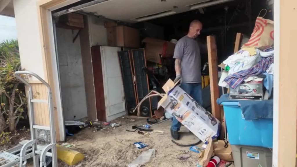 Hauler working through a packed garage, separating items that can still be donated