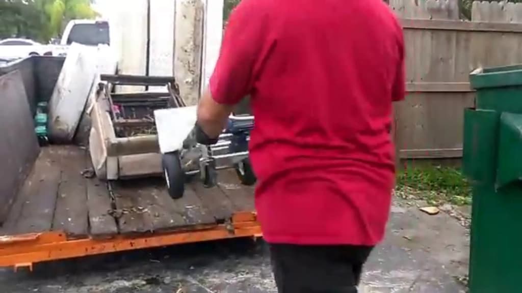 Hauler loading cleared material from a property onto a flatbed trailer