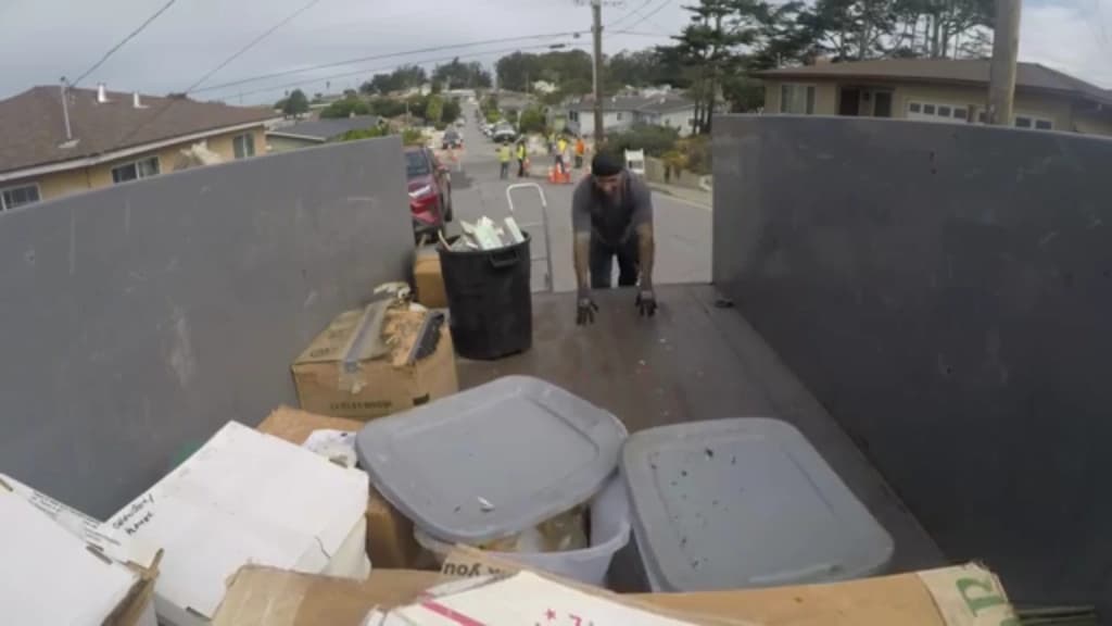 Truck bed part-loaded with bins, boxes and household items on a residential street