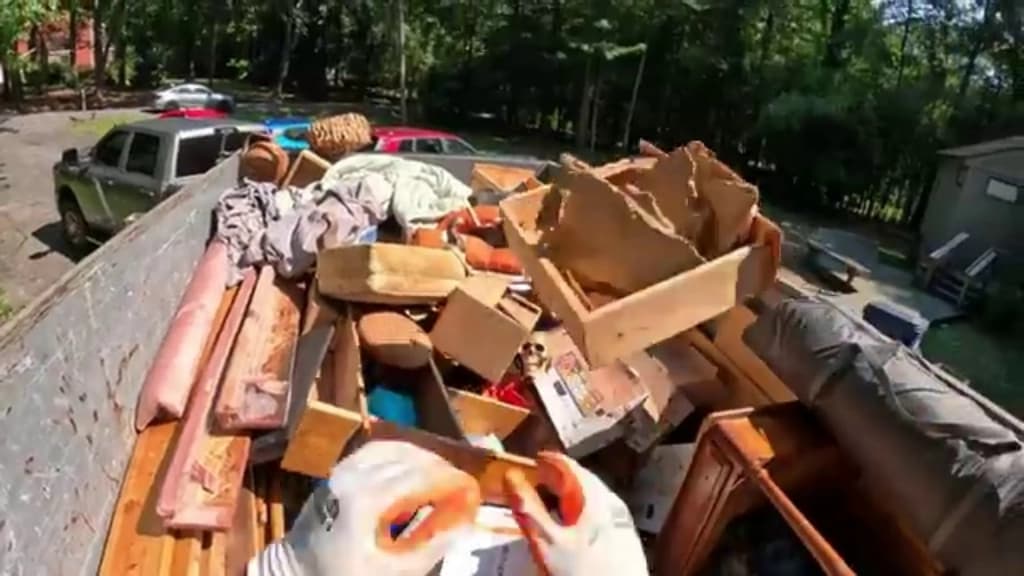 Dump truck loaded with lumber and renovation debris cleared from a Hemet remodel