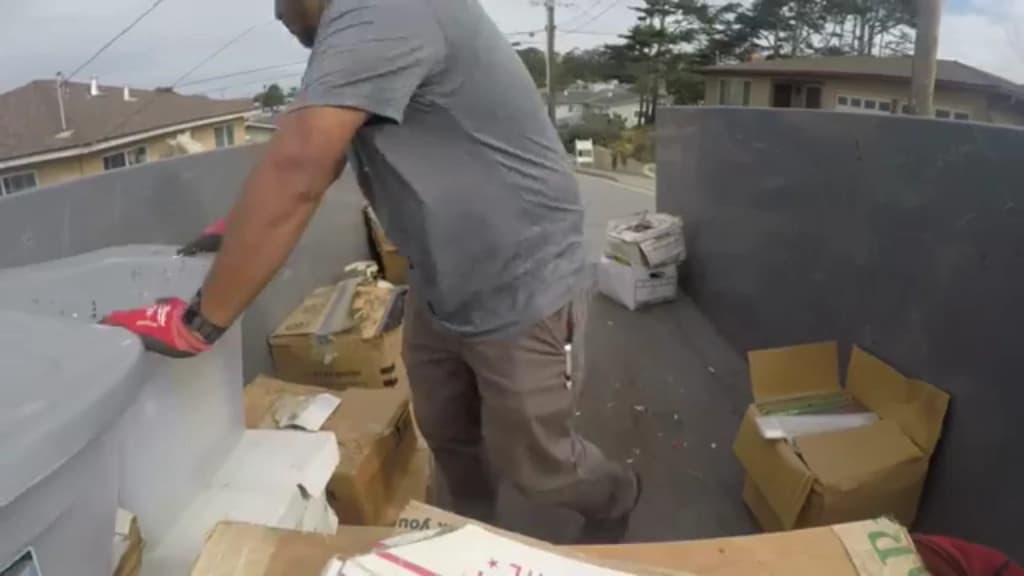Crew member lifting packed boxes into a container during an estate turnover