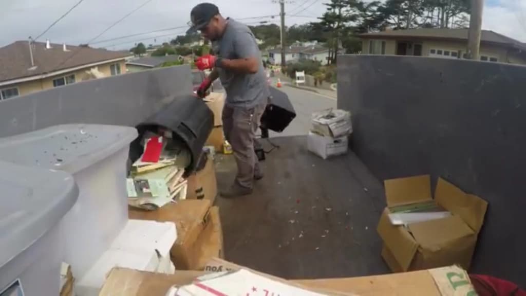 Crew breaking down and stacking furniture in the truck bed on a residential street